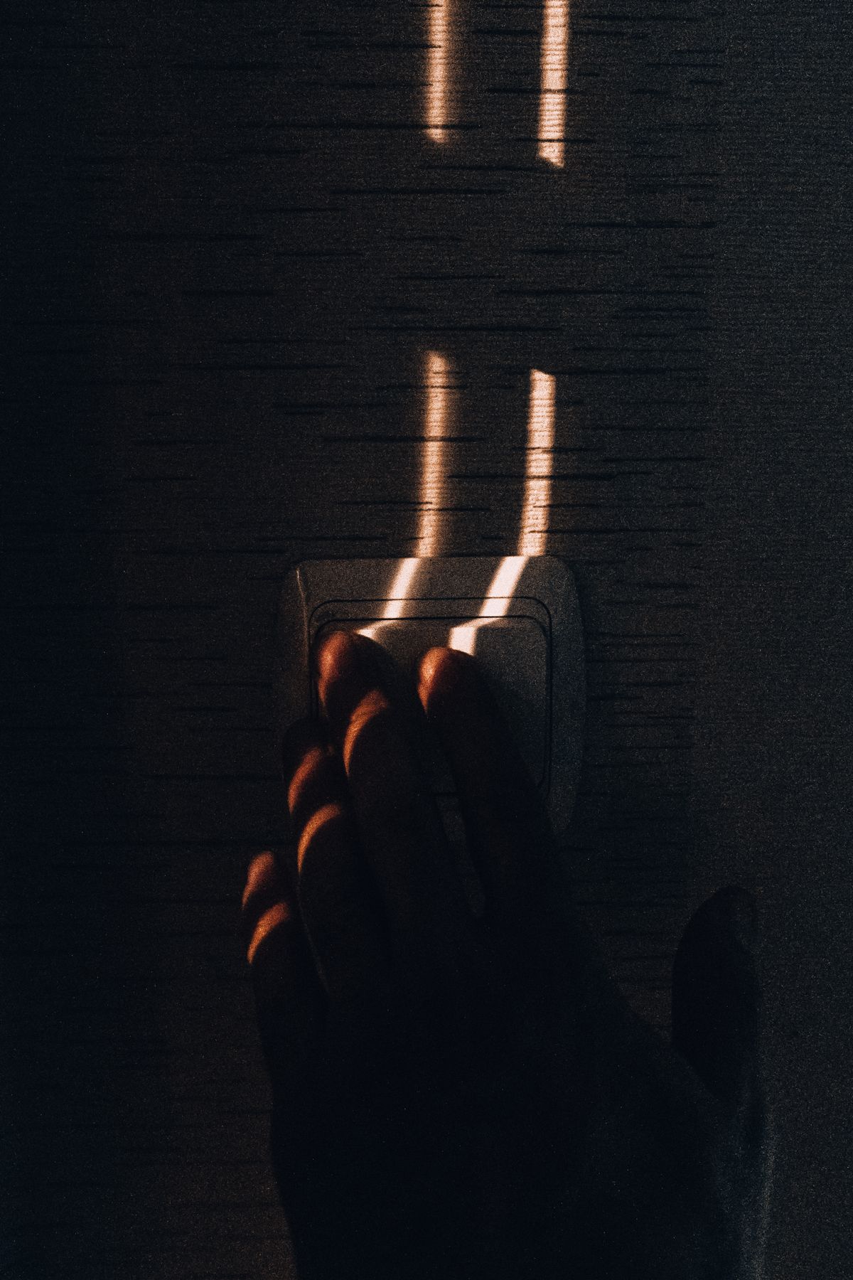 Hand reaching for a light switch