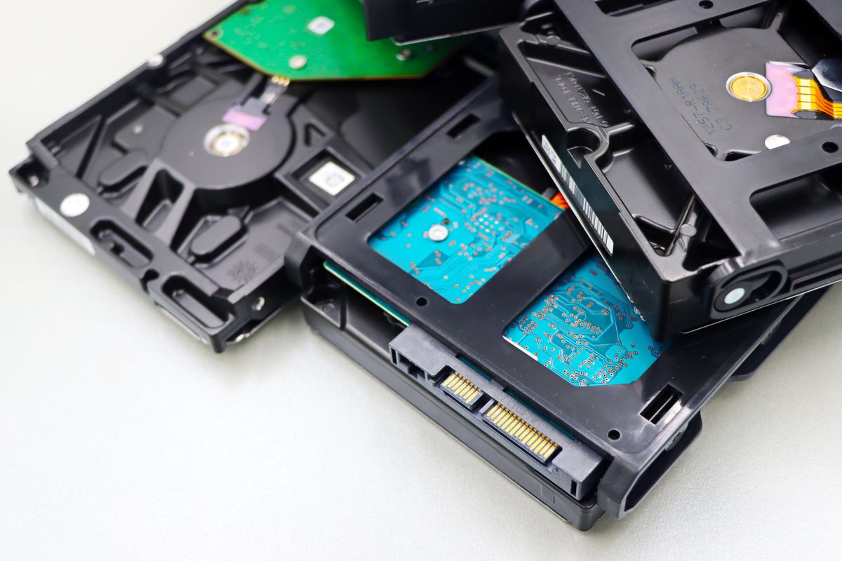Disassembled hard disk drives on a white surface