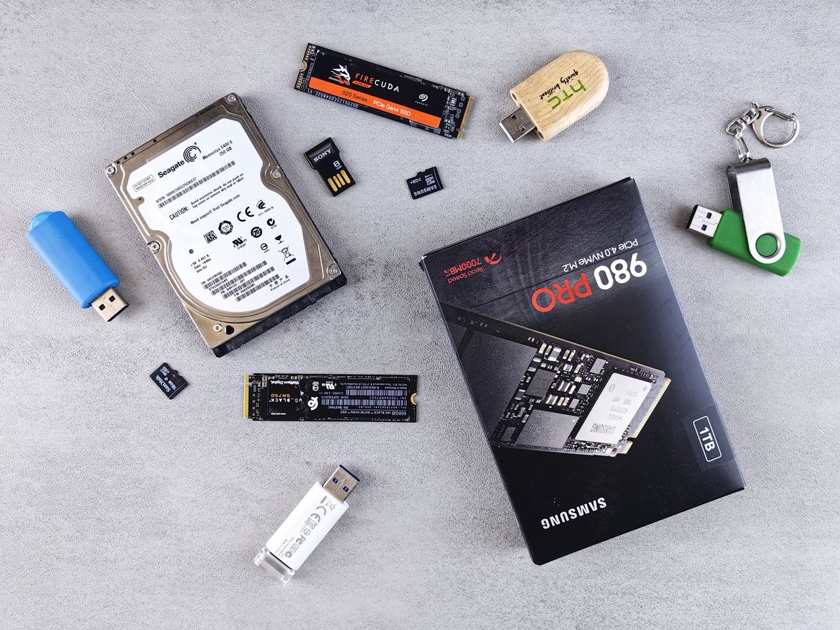 SSD, HDD, and removable storage devices arranged on a flat surface